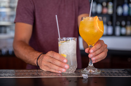 Barman prepared two cool alcoholic cocktails at Kastos island bar on a hot summer day.
