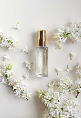 Perfume bottles with flowers on a light background. Perfumery, cosmetics, fragrance collection.