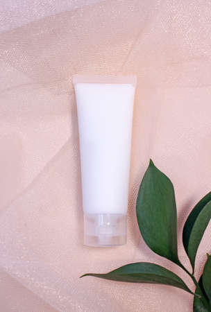 Mockup white plastic tube for moisturizer, lotion, facial cleanser or shampoo on smudged cream...