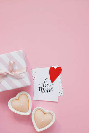 Happy Valentines Day composition. Blank greeting card mockup, gift boxes, red hearts, confetti on pink backgroundの写真素材