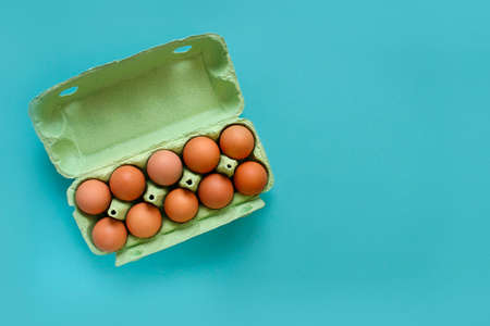 Organic eggs in cartons tray on blue background. Flat lay, top viewの写真素材