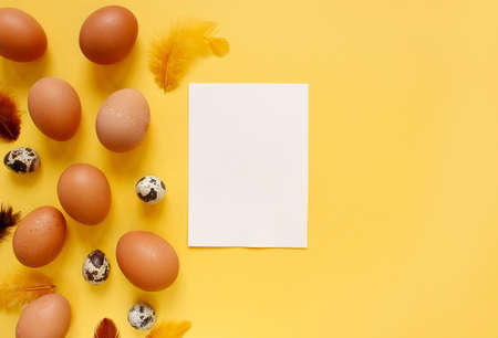 Happy Easter flat lay composition. Easter eggs decorated feathers on background. Flat lay, top view. Copy space.の写真素材