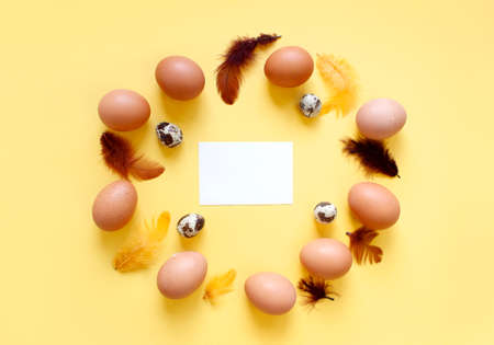 Happy Easter flat lay composition. Easter eggs decorated feathers on background. Flat lay, top view. Copy space.の写真素材