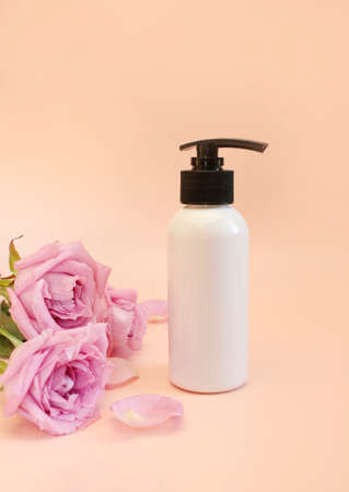 Beautiful composition with bottles rose flowers on pink background top view copy space. cosmetics collectionの写真素材