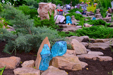 Rock garden. Artificial hill or bank built of earth and stones, and planted rock plants. Very interesting look live plants among the silent stones, if they complement each other.の写真素材