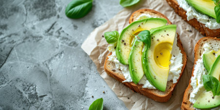 Sandwich with cream cheese and avocado slices on toasted bread. Healthy breakfast concept banner with copy space.の素材