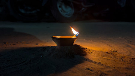 Diwali diya or oil lamp on the beach at night