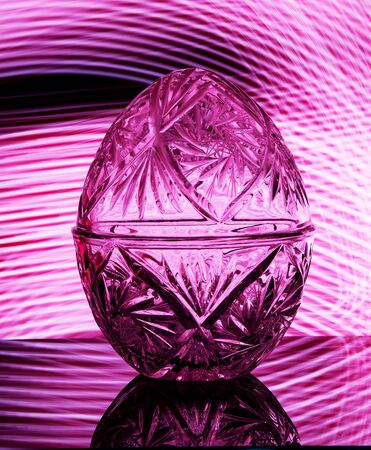 Crystal vase on a black background with pink lightingの写真素材