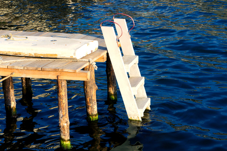 wooden staircase in the wate leading to the water blueの写真素材