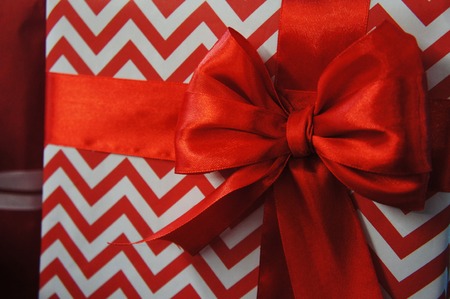 wrapped gift box background with stripes. red zigzag packaging for the holiday.の写真素材