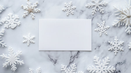 Blank white paper surrounded by snowflakes and snow on a gray background. winter holiday invitations. greeting cards. Christmas promotions seasonal announcements festive invitations. hite blank card in the center, surrounded by snowflakes, on a light grey background. Christmas concept. top view, mockup for text and design with copy space area. New year winter holiday banner template. Blank white card surrounded by snowflakes on grey background conveying. winter holiday, inviting festive messagesの写真素材