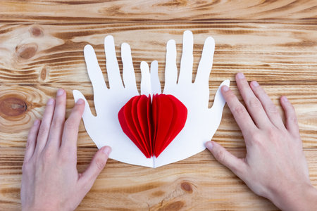 Craft paper heart in the palms for Valentine's Day. step by step instructions. DIY gift. final result.の写真素材