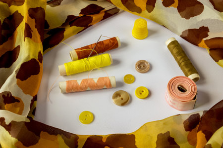 Sewing accessories: skeins of thread, buttons, fabric, thimble, needle and a centimeter on a white background. Needlework concept.の写真素材