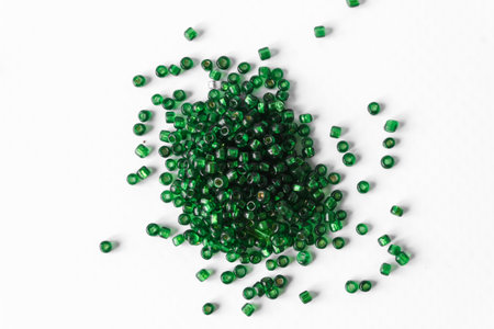Scattered pile of green beads on a white background. top view.の写真素材