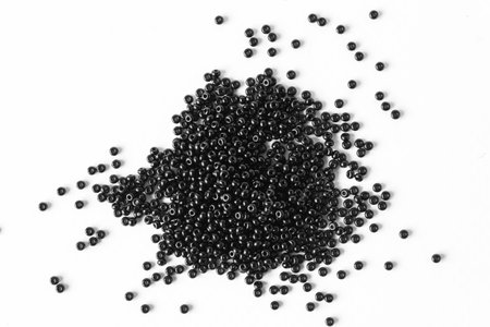 Scattered pile of black beads on a white background. top view.の写真素材