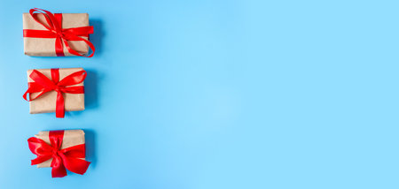 Gift boxes with a red bow on a blue background. Banner. copyspace. flat lay. top view. The concept of any holiday.の写真素材