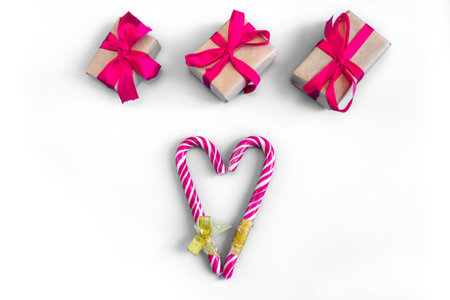 Gift boxes with caramel staffs in the form of a heart on a white background. postcard. The concept of Christmas and New Year.の写真素材
