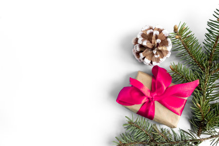 Gift boxes with pink bows, pine cones and fir branches on a white background. copyspace. flat lay. top view. Christmas and New Year concept.の写真素材