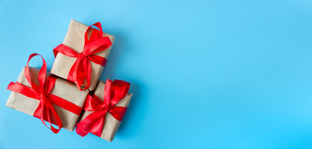Gift boxes with a red bow on a blue background. Banner. copyspace. flat lay. top view. The concept of any holiday.の写真素材
