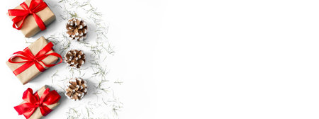 Gift boxes with red bows and pine cones on a white background. Banner. copyspace. flat lay. top view. The concept of any holiday.の写真素材