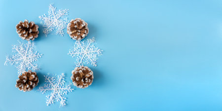 Pine cones with snowflakes on a blue background. banner. postcard. view from above. flat lay. copyspace.の写真素材