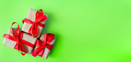 Gift boxes with a red bow on a green background. Banner. copyspace. flat lay. top view. The concept of any holiday.の写真素材