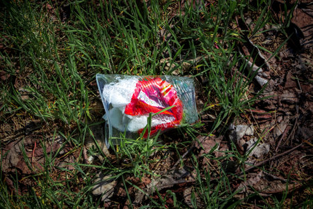 Thrown a plastic glass on the grass. The concept of environmental pollution with garbage and household waste disposal.の写真素材