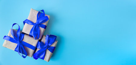 Gift boxes with a blue bow on a blue background. Banner. copyspace. flat lay. top view. The concept of any holiday.の写真素材