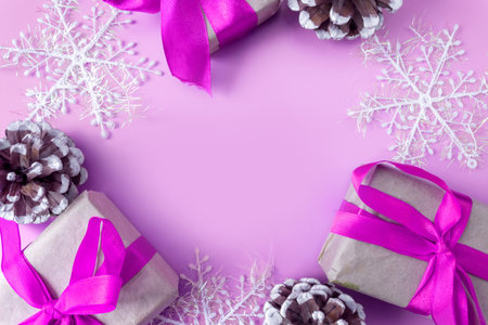 Christmas and New Year mockup on pink background. Frame made of snowflakes, cones and gift boxes. view from above. flat lay. copyspace.の写真素材