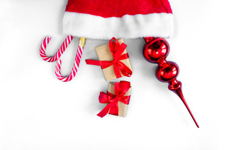 Santa Claus hat with caramel staffs, toy and gift boxes on a white background. postcard. The concept of Christmas and New Year.の写真素材
