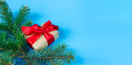 Gift boxes with red bows and fir branches on a blue background. Banner. copyspace. Christmas and New Year concept.の写真素材