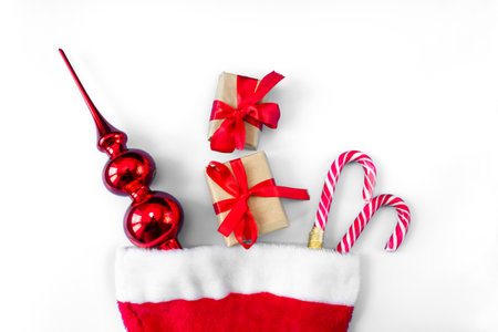 Santa Claus hat with caramel staffs, toy and gift boxes on a white background. postcard. The concept of Christmas and New Year.の写真素材