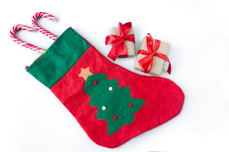 Christmas sock with gift boxes and caramel staffs on a white background. postcard. The concept of Christmas and New Year.の写真素材