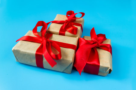 Gift boxes with a red bow on a blue background. The concept of any holiday.の写真素材