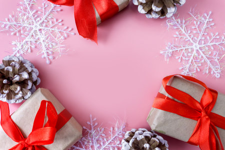 Christmas and New Year mockup on pink background. Frame made of snowflakes, cones and gift boxes. view from above. flat lay. copyspace.の写真素材