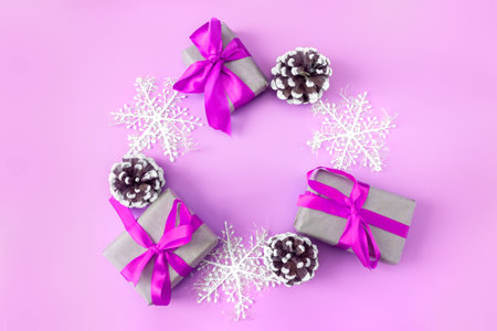 Christmas and New Year mockup on pink background. Frame made of snowflakes, cones and gift boxes. view from above. flat lay. copyspace.の写真素材