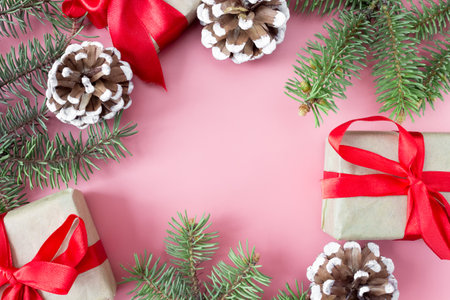 Christmas and New Year's layout on pink background.A frame of spruce branches, cones and gift boxes. top view. flat lay. copyspace.の写真素材