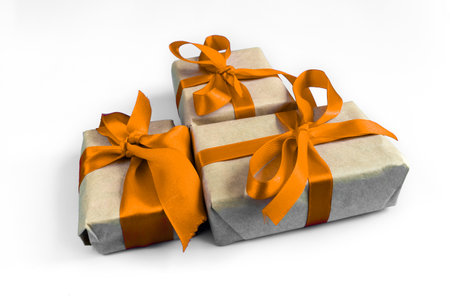 Gift boxes with a orange bow on a white background. The concept of any holiday.の写真素材