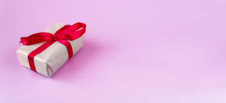 Gift box with ribbon on a pink background with place for text. copyspace.の写真素材