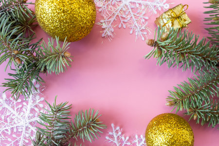 Christmas and New Year's layout on pink background. Frame made of fir branches, snowflakes and toys. top view. flat lay. copyspace.の写真素材