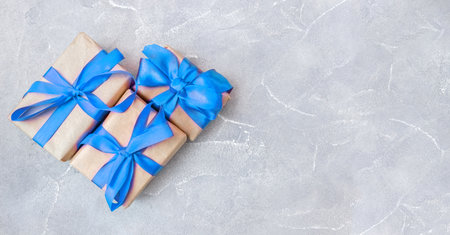 Gift boxes with a blue bow on concrete background. Banner. copyspace. flat lay. top view. The concept of any holiday.の写真素材