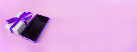 Smartphone with gift box on a pink background with place for text. Banner. postcard. copyspace.の写真素材