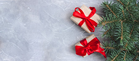 Festive gift boxes with spruce branches on concrete background. The concept of New Year and Christmas. flatlay. copyspace. postcard. Banner.の写真素材