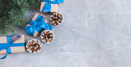 Festive gift boxes with fir branches and cones on a concrete background. New Year and Christmas concept. flatlay. copyspace. postcard.の写真素材