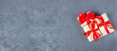 Gift boxes with a red bow on concrete background. Banner. copyspace. flat lay. top view. The concept of any holiday.の写真素材