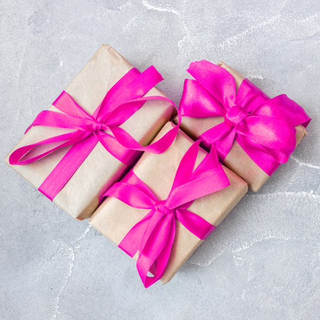 Gift boxes with a pink bow on concrete background. Banner. flat lay. top view. The concept of any holiday.の写真素材
