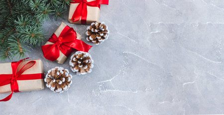 Festive gift boxes with fir branches and cones on a concrete background. New Year and Christmas concept. flatlay. copyspace. postcard.の写真素材