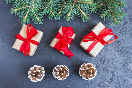 Festive gift boxes with spruce branches and pinecone on concrete background. The concept of New Year and Christmas. flatlay. postcard.の写真素材