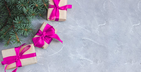 Festive gift boxes with spruce branches on concrete background. The concept of New Year and Christmas. flatlay. copyspace. postcard. Banner.の写真素材