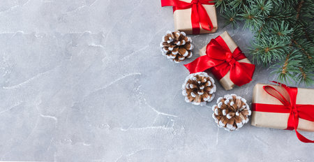 Festive gift boxes with fir branches and cones on a concrete background. New Year and Christmas concept. flatlay. copyspace. postcard.の写真素材